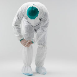 Man putting on boot covers in a cleanroom